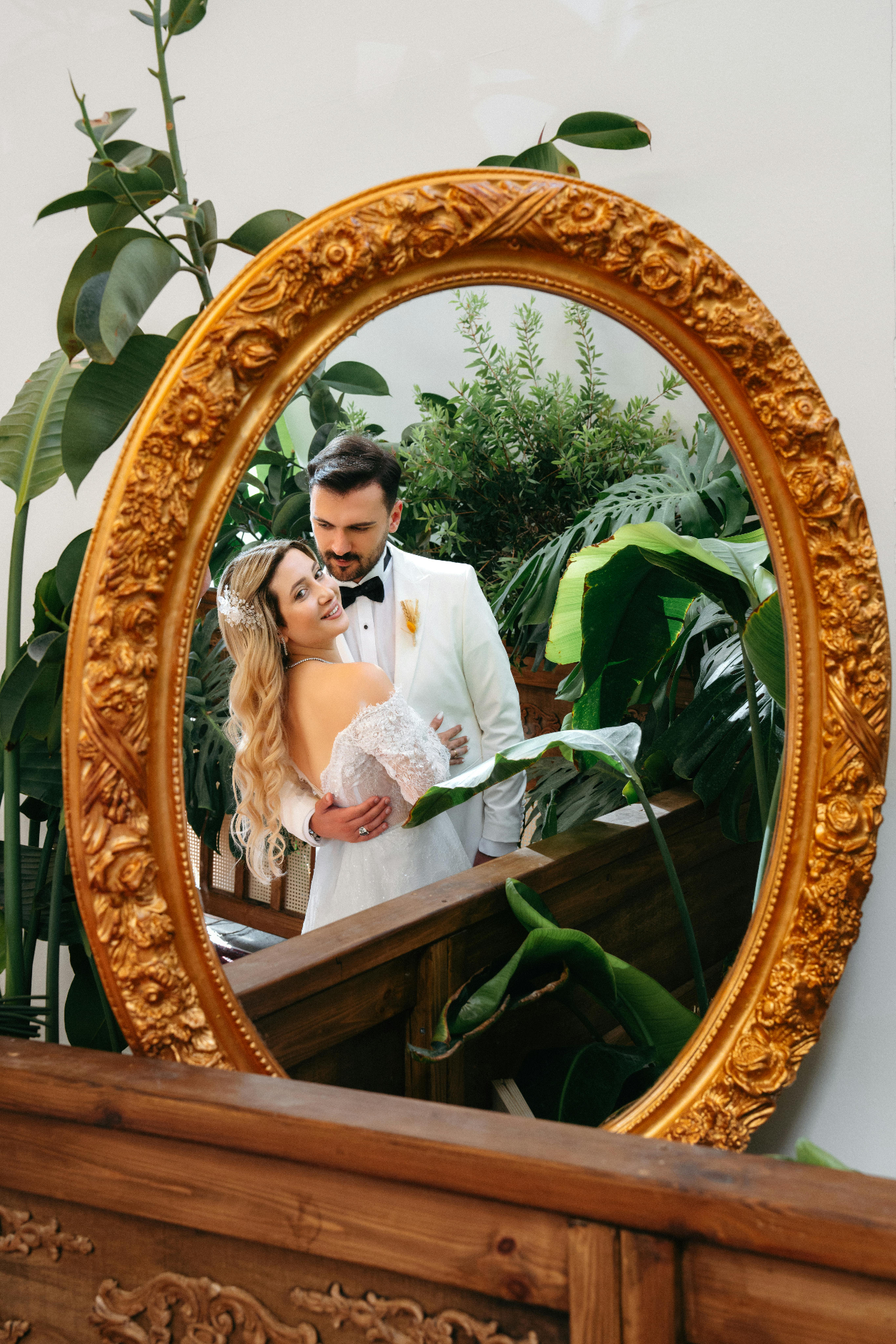 Altın çerçeveli ayna yansımasında gelin damat